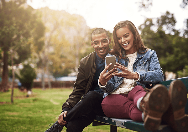 Smiling pair looking at smartphone together
