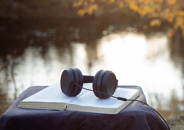 Headphones resting on open book outdoors