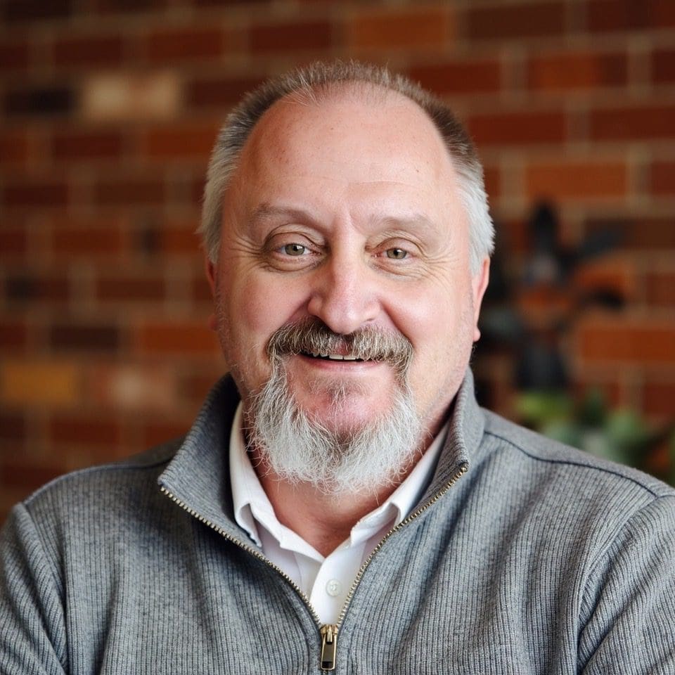 Smiling man with a beard indoors.