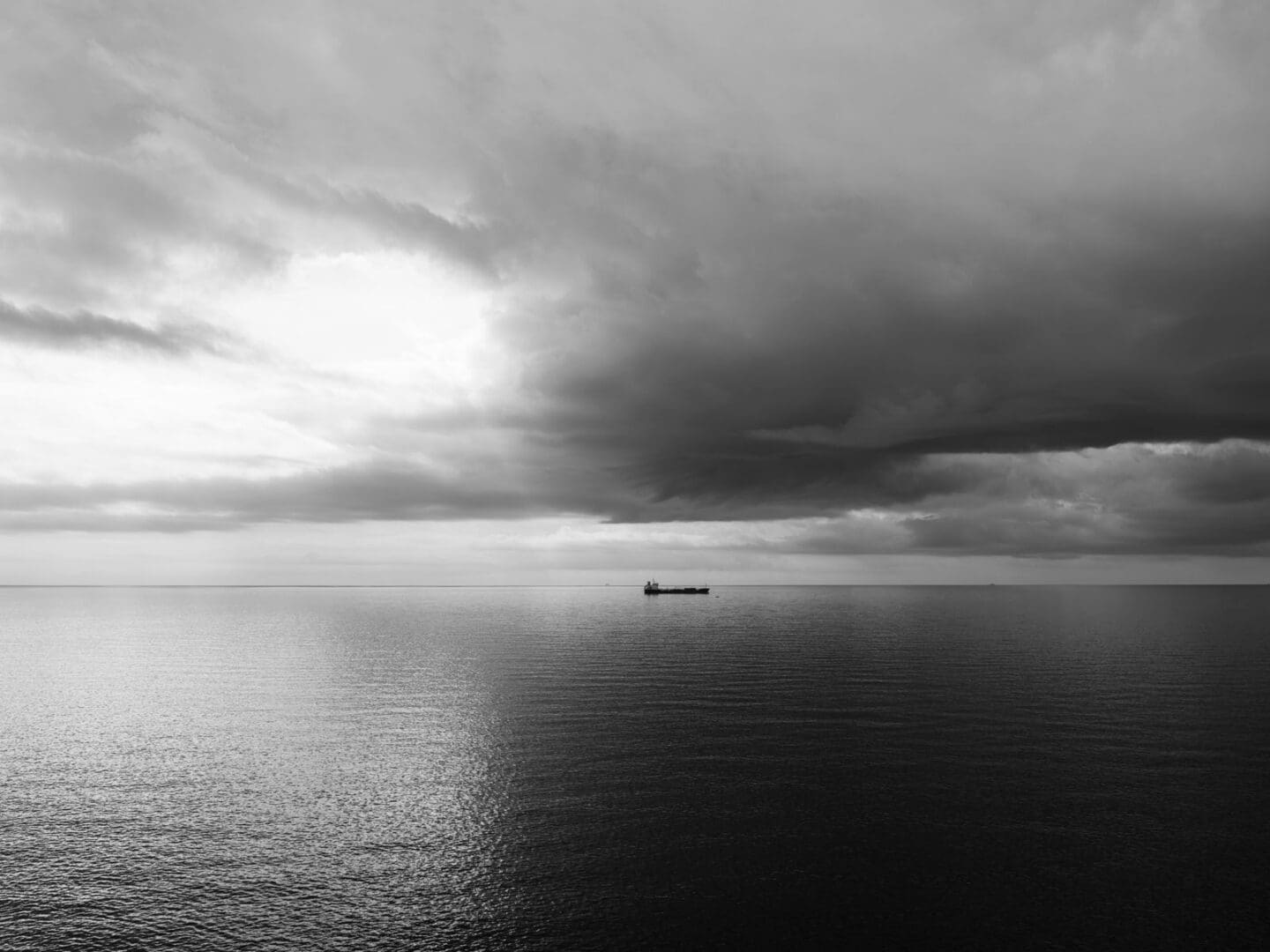 A solitary ship crossing a stormy sea at dawn, a picture of faith holding steady through suffering
