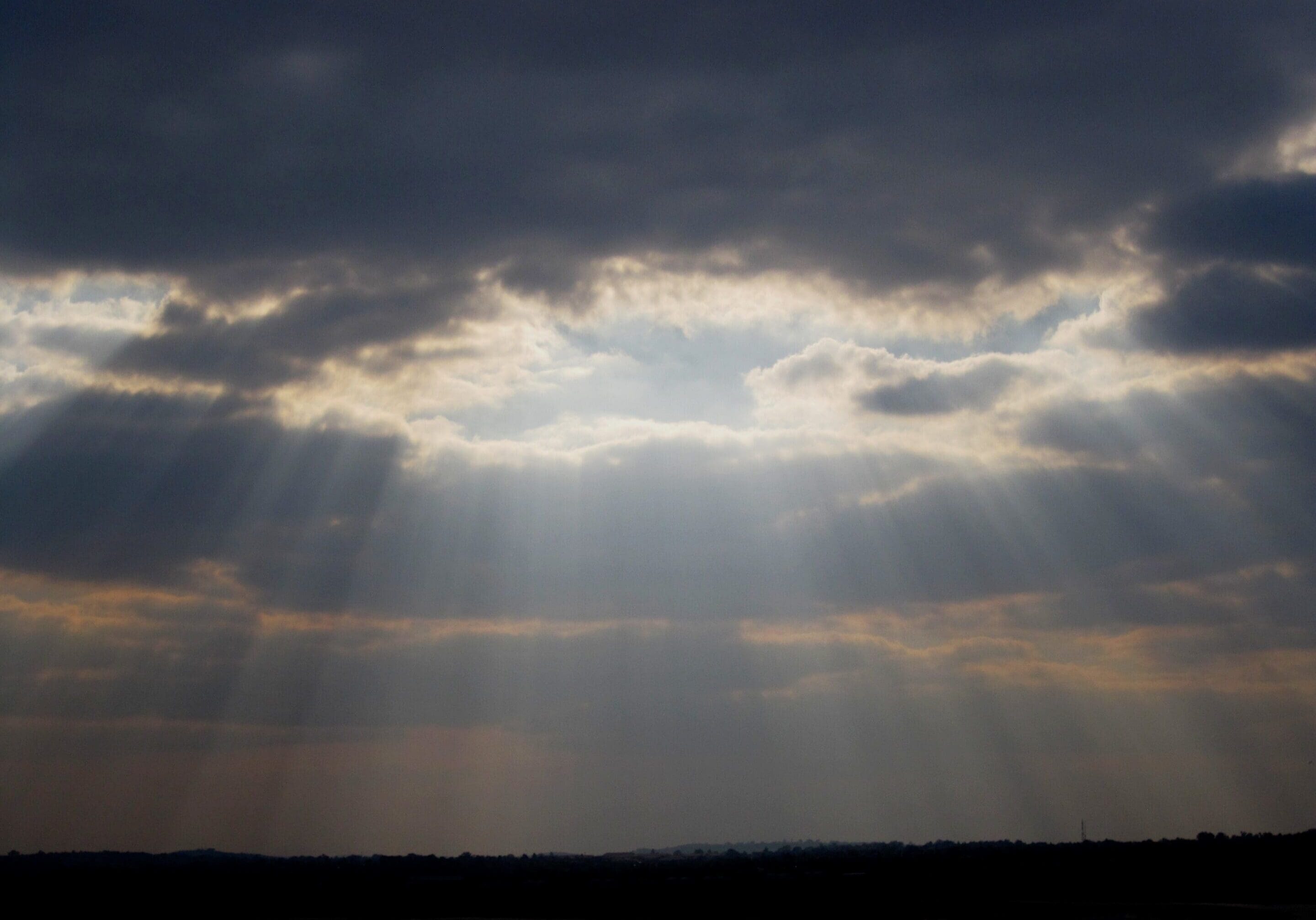 Sunlight breaking through clouds — a visual of grace defined, the smile of God breaking into our lives.